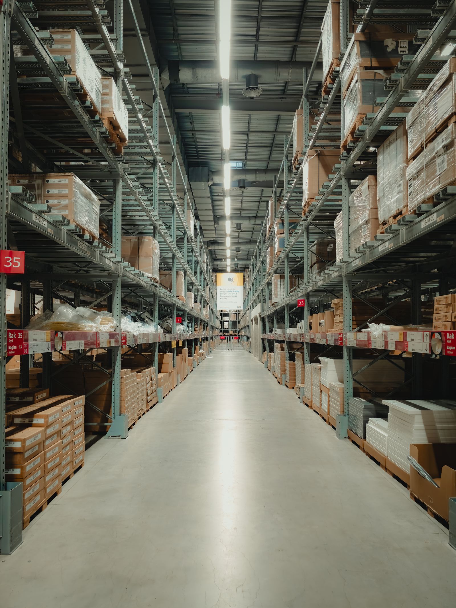 Zichuan Home Long warehouse aisle lined with stacked inventory on shelves