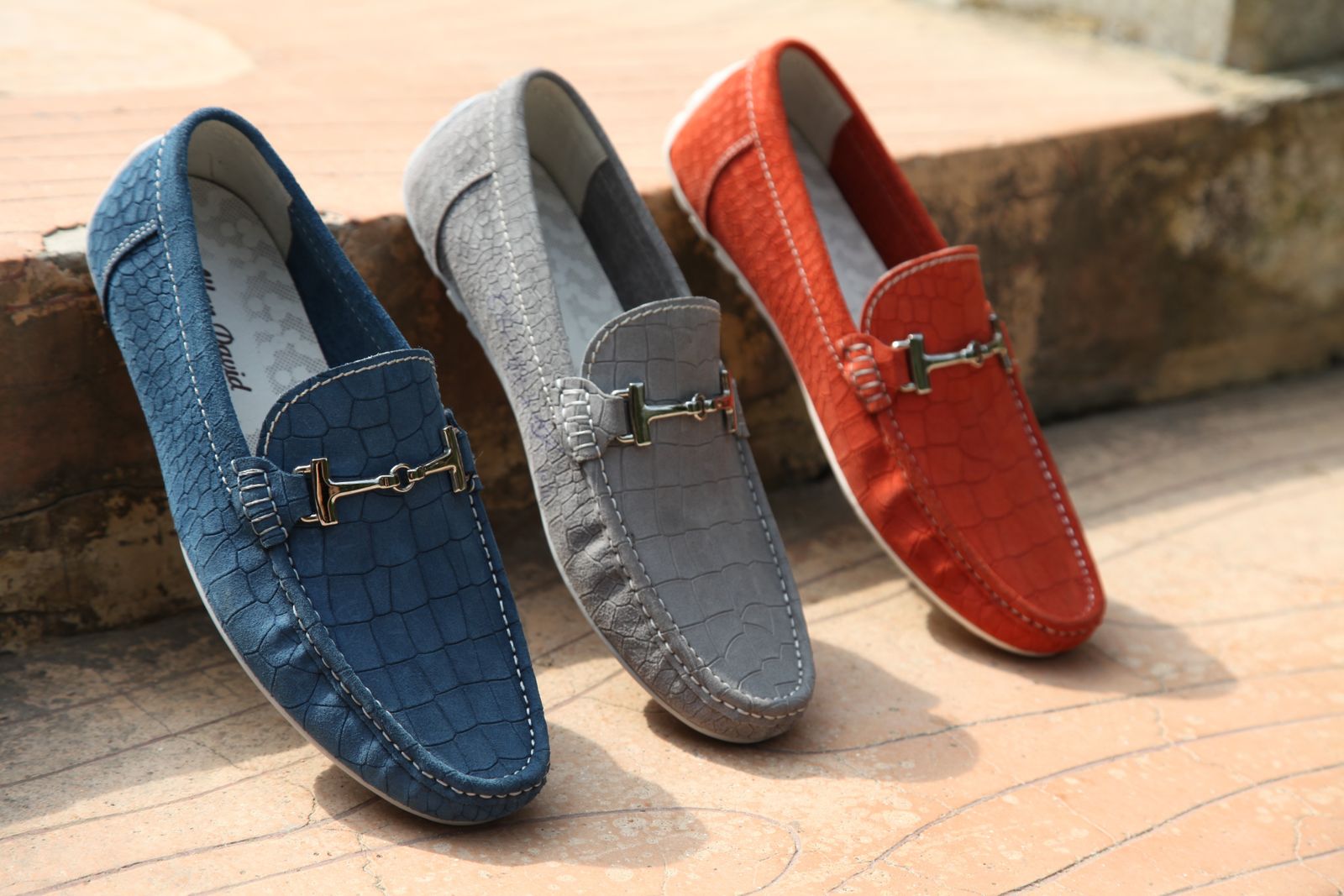 Blue gray and orange loafers displayed as a footwear product set