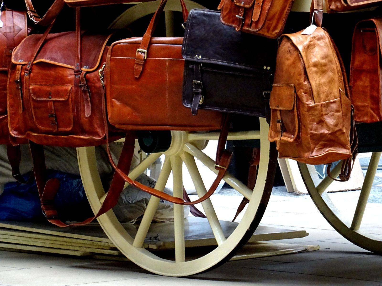 Leather handbags arranged on a wooden wheel