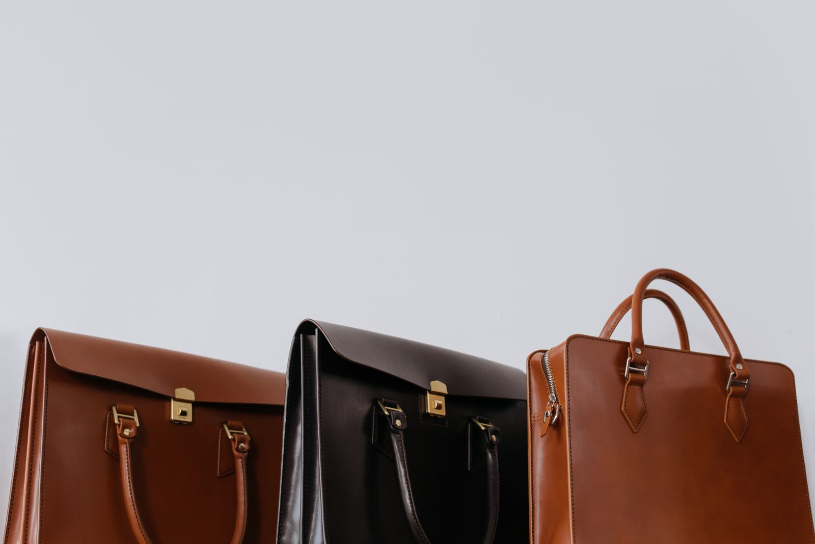 Close-up of three elegant leather briefcases